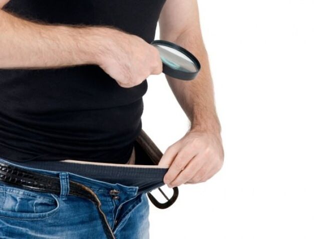 Ένας άντρας κοιτάζει κάτω το παντελόνι του και θέλει να μεγεθύνει το πέος του